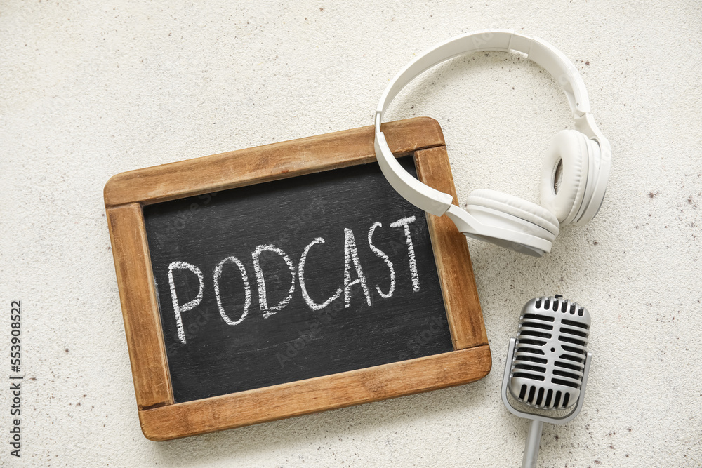 Chalkboard with word PODCAST, headphones and microphone on white background
