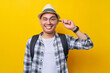 © Bangun Stock Photo - traveler fun explorer tourist Asian man in casual clothes hat looking through magnifier loupe isolated on yellow background. Air flight journey concept
