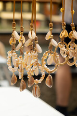 Jewelery showcase sea decorations on street market. Woman choosing decorations on local street market in Gdansk, Poland. Female tourist is choosing souvenirs in street shop and looking at color