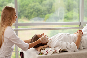 Wall Mural - Beautiful african woman getting face massage in beauty spa