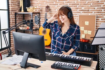 Poster - Young woman musician playing piano keyboard at music studio