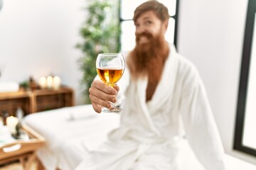 Poster - Young redhead man wearing bathrobe drinking champagne at beauty center