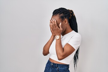 Wall Mural - Beautiful black woman standing over isolated background with sad expression covering face with hands while crying. depression concept.