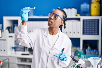 Sticker - African american woman scientist holding pills at laboratory