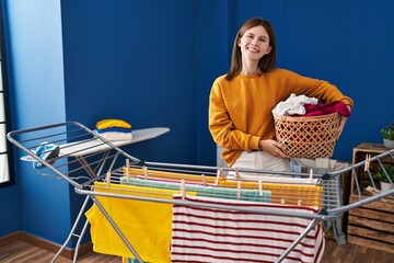 Sticker - Young brunette woman hanging clothes at clothesline looking positive and happy standing and smiling with a confident smile showing teeth