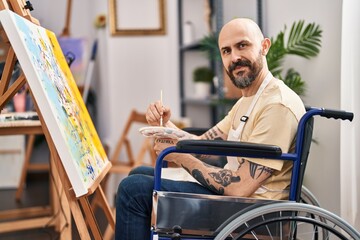 Poster - Young bald man artist sitting on wheelchair drawing at art studio