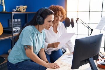 Poster - Two women musicians composing song using computer at music studio