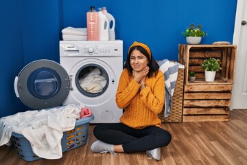 Canvas Print - Young hispanic woman doing laundry shouting suffocate because painful strangle. health problem. asphyxiate and suicide concept.