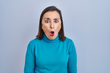 Poster - Middle age hispanic woman standing over isolated background afraid and shocked with surprise expression, fear and excited face.