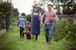 © Caia Image - Family with baskets walking in garden grass