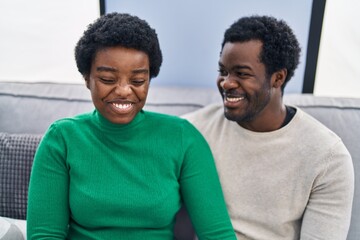 Poster - African american man and woman couple smiling confident sitting together at home