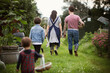 © Caia Image - Family walking in backyard garden grass