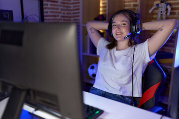 Wall Mural - Young caucasian woman streamer smiling confident relaxed with hands on head at gaming room