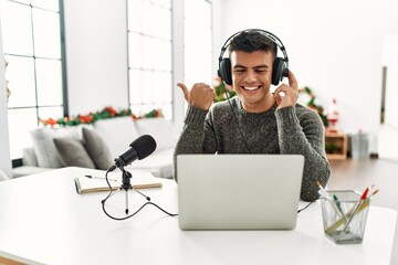 Sticker - Handsome hispanic man recording podcast pointing thumb up to the side smiling happy with open mouth