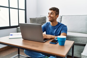 Sticker - Young hispanic man using laptop sitting on the floor at home