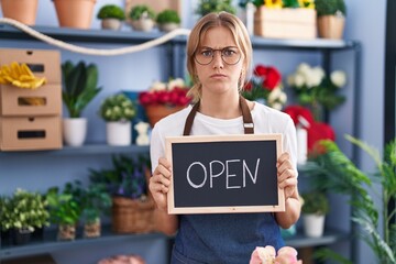 Wall Mural - Young caucasian woman working at florist with open sign skeptic and nervous, frowning upset because of problem. negative person.