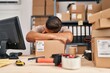 © Krakenimages.com - Young latin man ecommerce business worker leaning on package sleeping at office