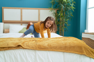 Poster - Adorable hispanic girl smiling confident standing on bed at bedroom