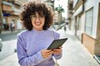 © Krakenimages.com - Young middle east woman smiling confident using touchpad at street