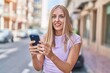 © Krakenimages.com - Young blonde woman smiling confident using smartphone at street