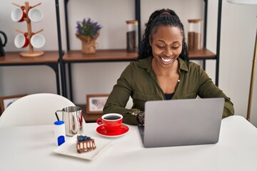 Poster - African american woman having breakfast using laptop at home