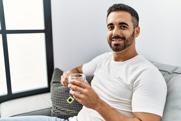 Wall Mural - Young hispanic man smiling confident drinking tea at home