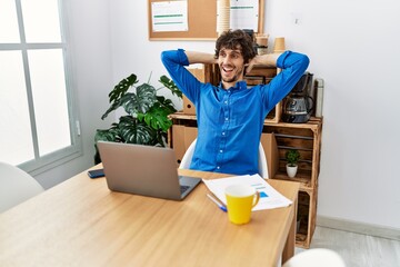 Wall Mural - Young hispanic man relaxed with hands on head at office