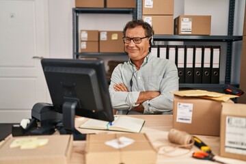 Wall Mural - Senior man working at small business ecommerce wearing headset happy face smiling with crossed arms looking at the camera. positive person.