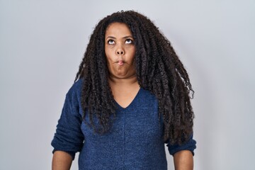 Poster - Plus size hispanic woman standing over white background making fish face with lips, crazy and comical gesture. funny expression.