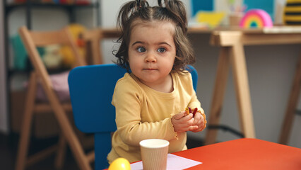 Canvas Print - Adorable hispanic girl student sitting on table drawing on paper at kindergarten