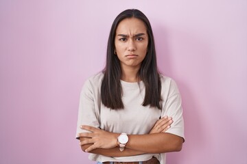 Sticker - Young hispanic woman standing over pink background skeptic and nervous, disapproving expression on face with crossed arms. negative person.