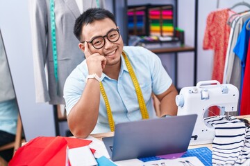 Sticker - Young chinese man tailor smiling confident using laptop at tailor shop