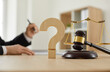 © Studio Romantic - Close up of a wooden question mark and gavel on the judge's table in the courtroom or on the desk in the lawyer's office. Concept of law, justice, court trial, and professional legal services