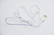 © Lushchikov Valeriy - White USB cable for charging the phone on a white background. White cord for charging gadgets.
