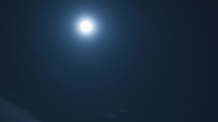 Wall Mural - a full moon and some stars in the winter sky. faintly visible clouds fly in front of the moon. a win