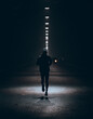 silhouette of a runner in the dark alley in the park