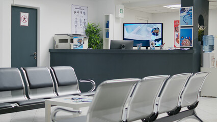 Wall Mural - Empty hospital waiting room in lobby with reception counter at medical facility, used to help patients with appointments and healthcare insurance. Medical waiting area with front desk.