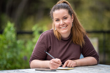 mature university student writing outside studying