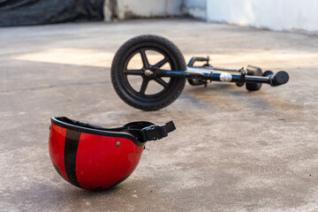 Small bike and a helmet lying on the road