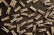 wooden clothespins for clothes scattered on a brown background