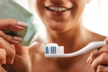 Wall Mural - Close up of putting toothpaste on a toothbrush