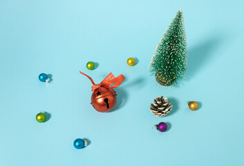 Wall Mural - Christmas tree, baubles, red bell and pinecone on pastel cyan background