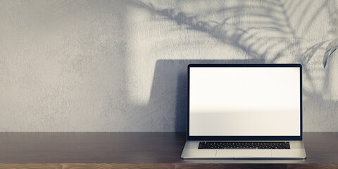 Poster - Laptop mockup on wooden table, grey plaster wall and palm tree shadow. Laptop with blank screen mockup. Front view laptop on work table, grey background. copy space