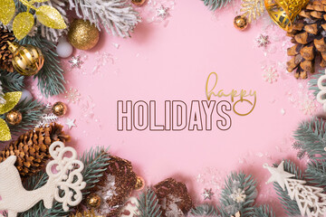 Wall Mural - Happy Holidays greeting text with Christmas decoration on pink background. New Year Xmas greeting card