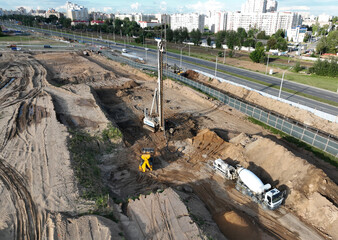 Poster - Deep foundation machine. Drilling rig and Pile driver at construction site. Pile driven into ground by vibrating hydraulic hammer. Cement mixer truck pouring concrete on construction work. Formworks.