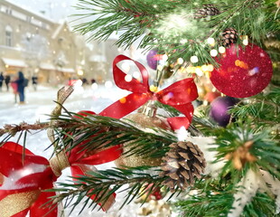 Wall Mural - winter Christmas City decoration pine tree branch with red ball and illumination ,snowfall,people walk on snowy street in medieval Tallinn old town