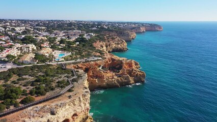 Wall Mural - Beautiful aerial views of the seaside tourist town of Carvoeiro with cliff beaches and traditional Portuguese houses.