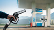 © scharfsinn86 - Hand with H2 nozzle on a background of hydrogen filling station. Clean mobility concept