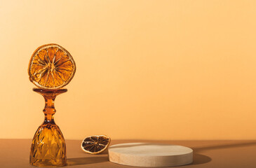 Wooden textured round low podium on a warm background. Background for photography products, organic cosmetics, eco products. Glass shot and dried citrus slices.