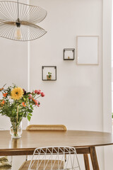 Wall Mural - flowers in a vase sitting on a wooden table next to a white wall with black framed pictures hanging above it